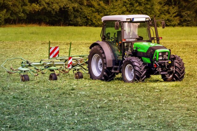 Un trattore che taglia l'erba nei campi