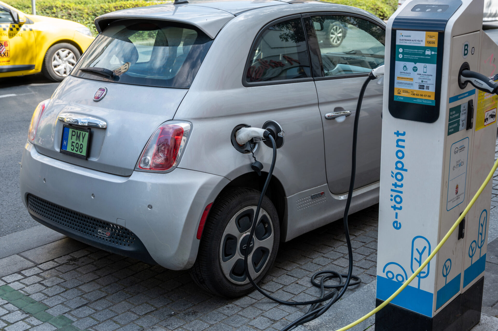 macchina elettrica economica compatta in ricarica presso colonnina pubblica in città