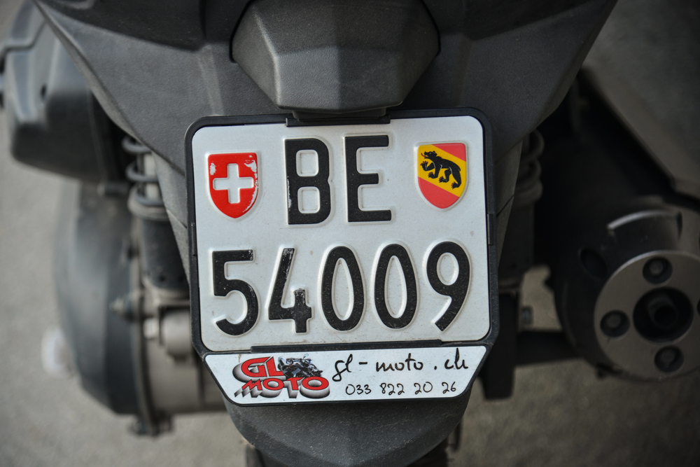 Targa moto in primo piano sul retro di uno scooter, utile per guida su rifare targa moto e duplicato targa moto.